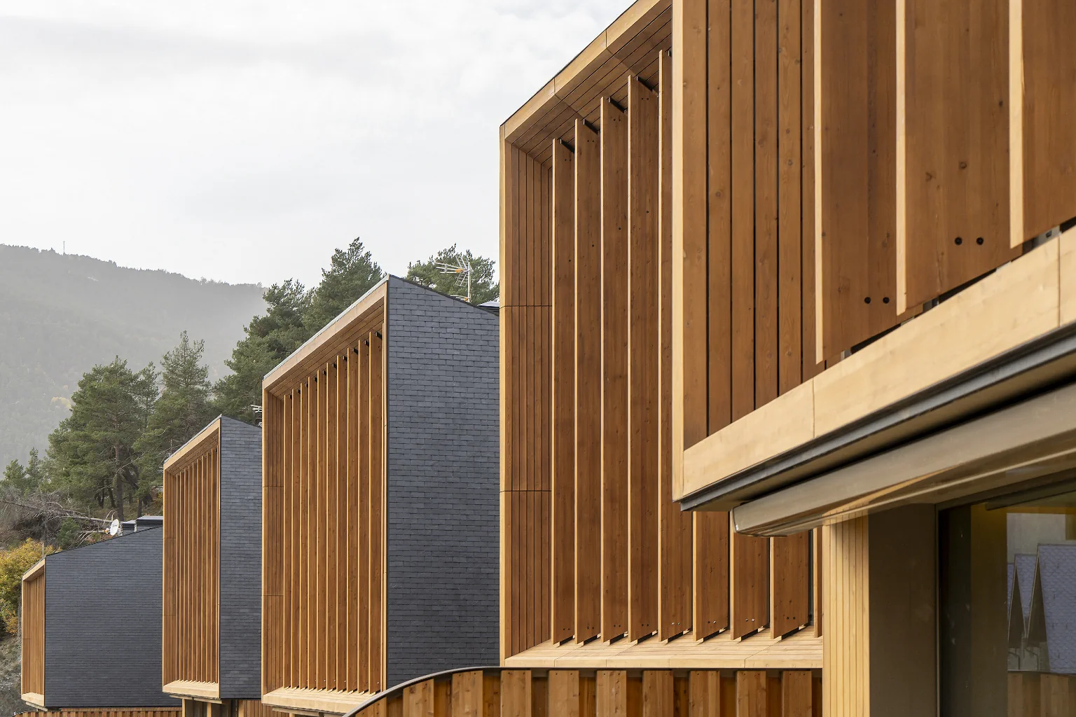 Façanes d’Aldosa Village a La Massana amb arquitectura contemporània, revestiments de fusta i integració amb l’entorn natural.